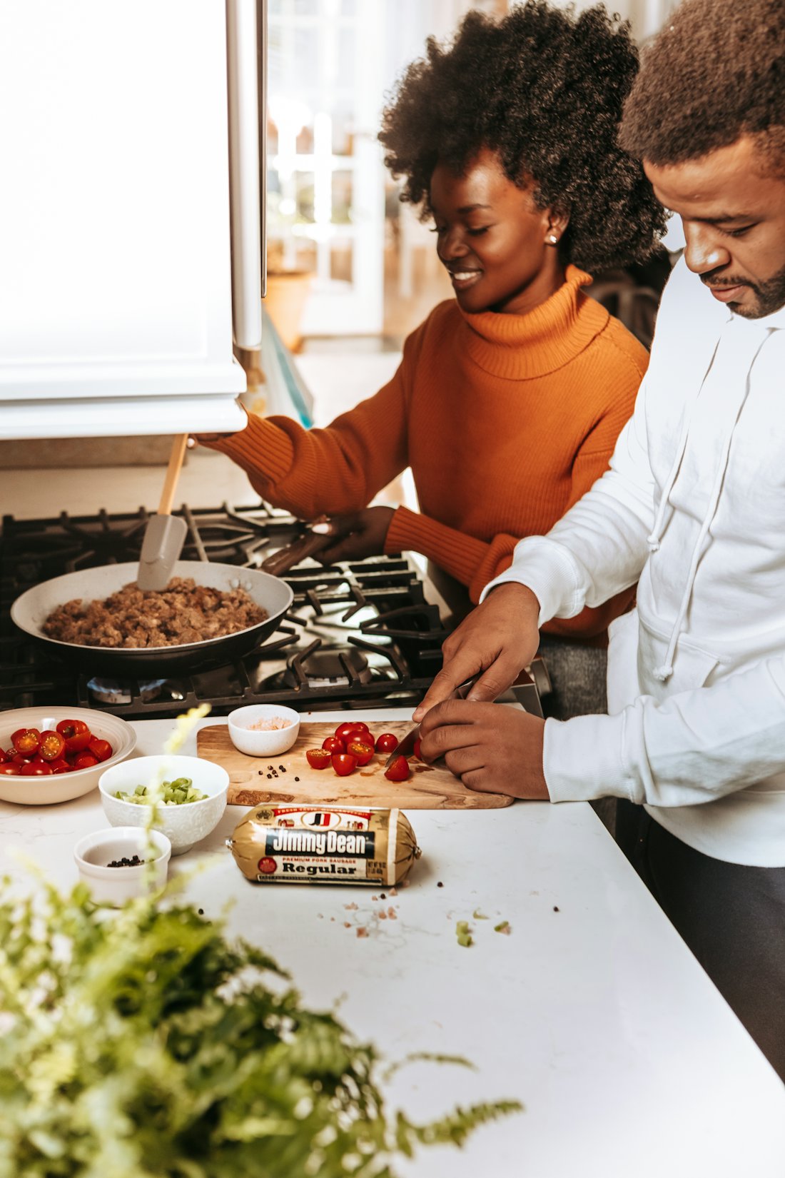 A couple cooking dinner together at home